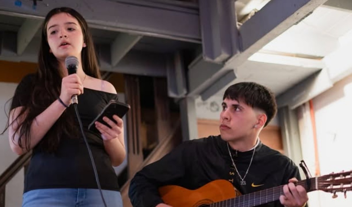 Estudiante canta acompañada por guitarra
